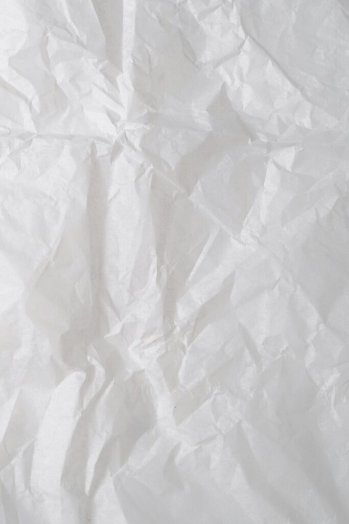 Close-up of crumpled white paper, perfect for backgrounds or texture designs.